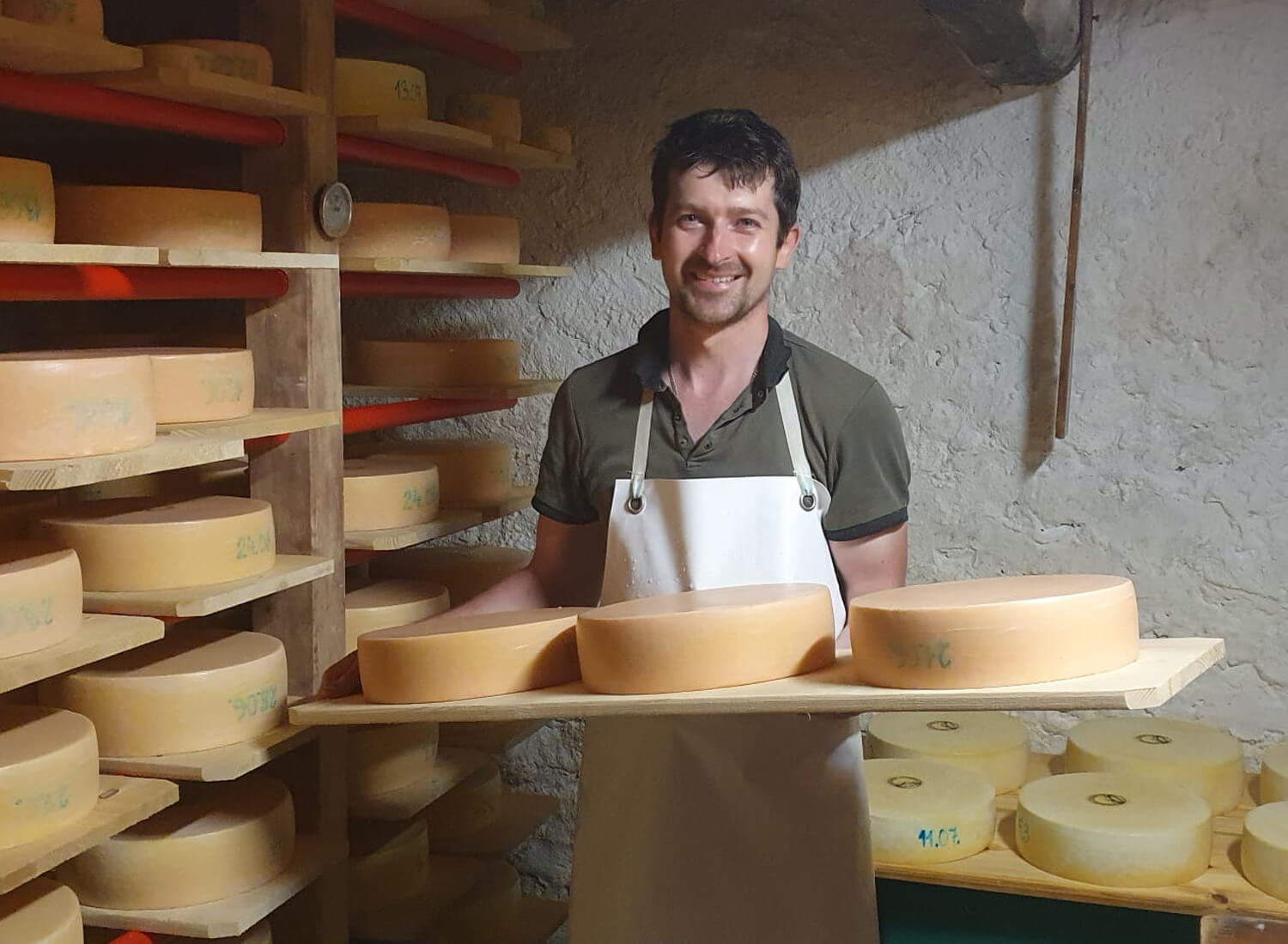 Mann mit Käse im Käsekeller